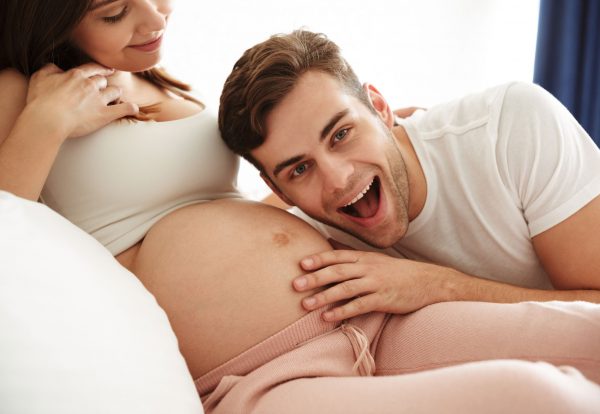 happy-young-man-listening-his-pregnant-wife-s-belly